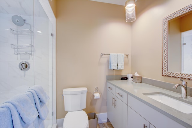 bathroom with vanity, toilet, and tiled shower