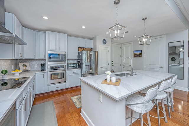 125 Pier View St Unit 408, Charleston, SC 29492 - kitchen featuring stainless steel appliances, wall chimney range hood, light wood finished floors, decorative backsplash, and recessed lighting