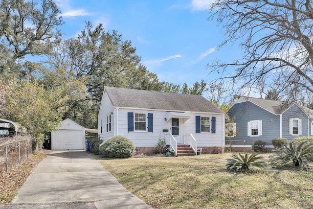 view of front of house featuring concrete driveway, a detached garage, fence, an outdoor structure, and a front yard