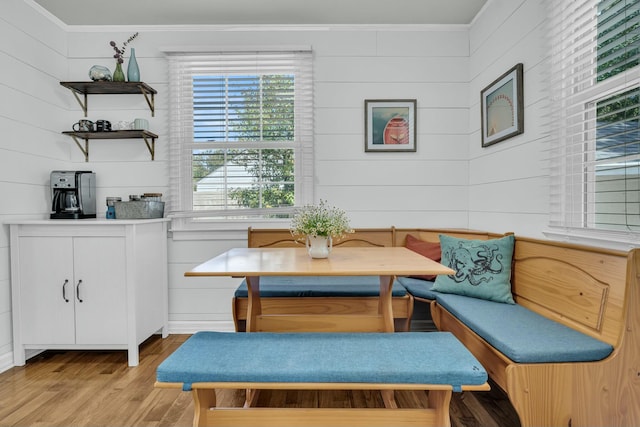 dining room with light wood-style floors, breakfast area, and crown molding