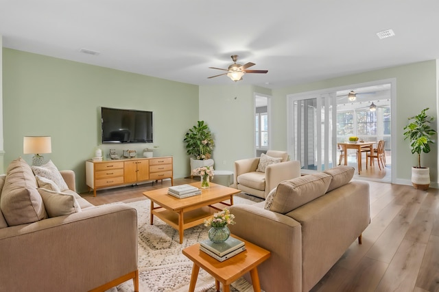 living room with plenty of natural light and light hardwood / wood-style flooring