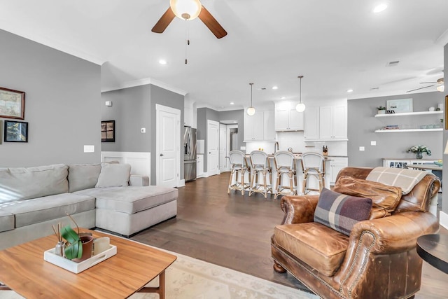 living room featuring crown molding, light hardwood / wood-style floors, and ceiling fan