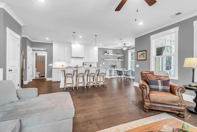 living room featuring crown molding, dark hardwood / wood-style floors, and ceiling fan