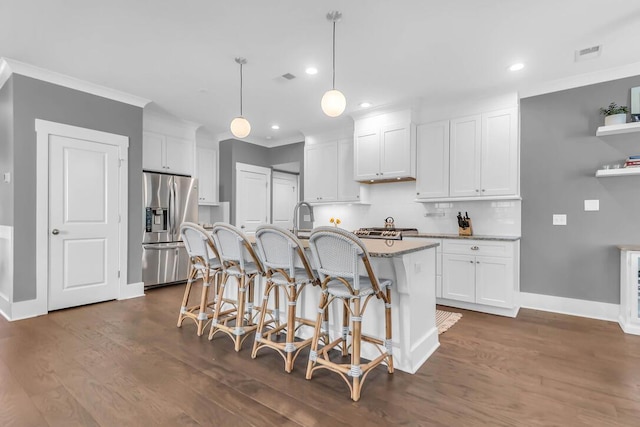 kitchen featuring white cabinetry, stainless steel refrigerator with ice dispenser, a kitchen island with sink, and pendant lighting