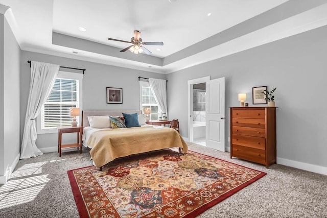 carpeted bedroom featuring connected bathroom, ceiling fan, and a tray ceiling