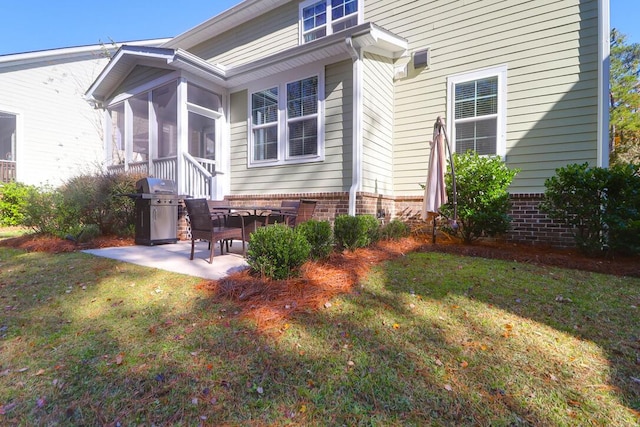 rear view of property featuring a sunroom, a yard, and a patio