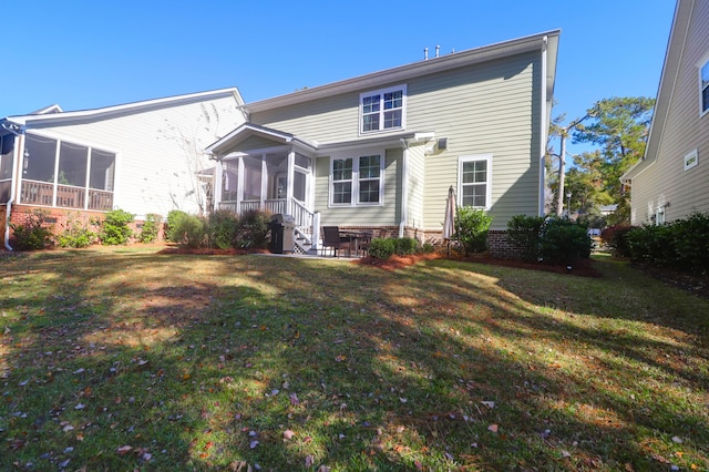 back of property featuring a sunroom and a lawn