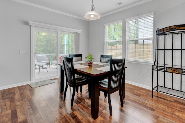 dining space with visible vents, crown molding, baseboards, and wood finished floors