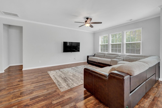 living area with a ceiling fan, wood finished floors, visible vents, and crown molding