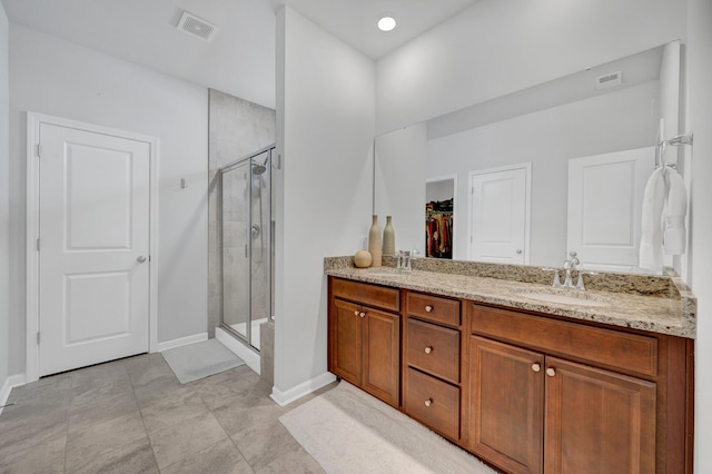 full bath with a sink, visible vents, and a shower stall