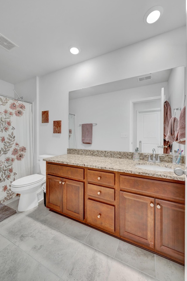 bathroom featuring toilet, vanity, visible vents, and a shower with curtain