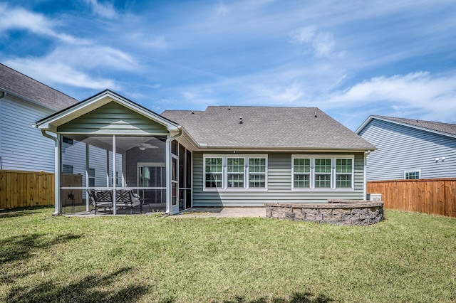 back of property featuring a yard, roof with shingles, a fenced backyard, and a sunroom