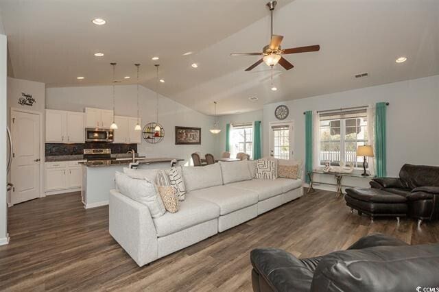 living room with dark wood-type flooring, high vaulted ceiling, and ceiling fan