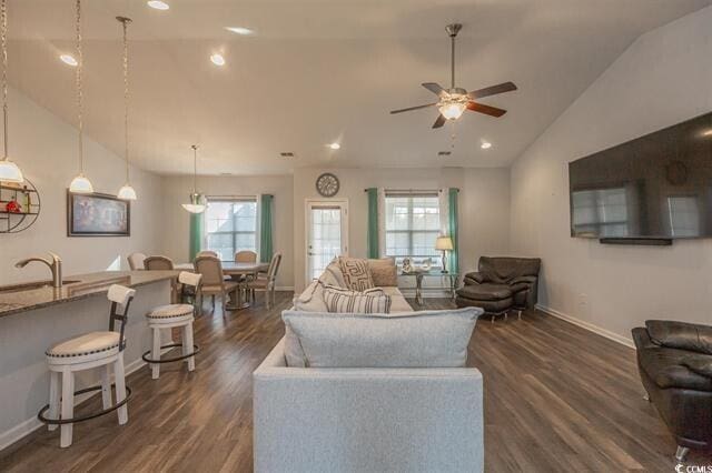 living room with lofted ceiling, ceiling fan, dark hardwood / wood-style floors, and plenty of natural light