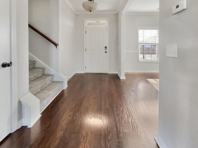 foyer entrance with crown molding and dark hardwood / wood-style floors