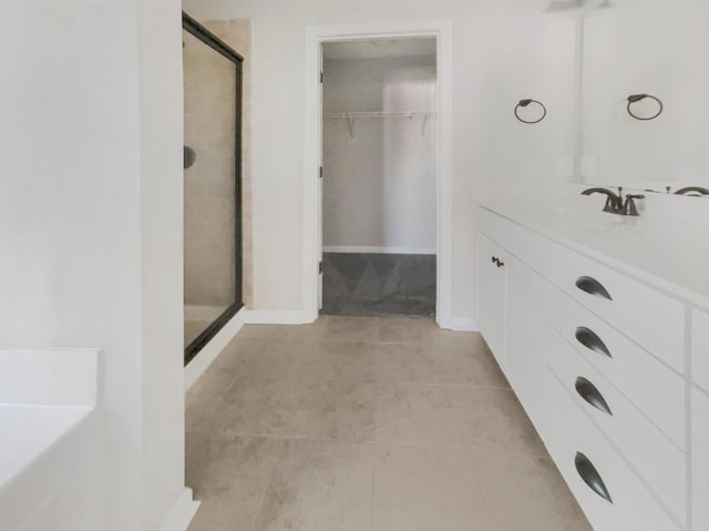 bathroom featuring vanity, tile patterned flooring, and a shower with shower door