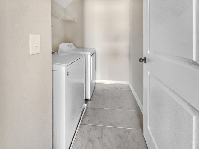 laundry area featuring light tile patterned flooring and washer and clothes dryer