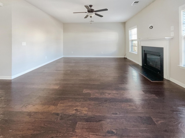 unfurnished living room with dark hardwood / wood-style flooring and ceiling fan