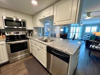 kitchen featuring appliances with stainless steel finishes, kitchen peninsula, and white cabinetry