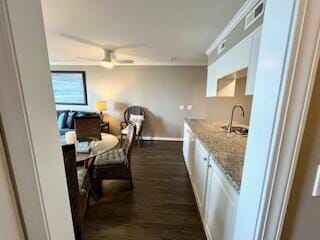 kitchen featuring ceiling fan, dark wood-type flooring, sink, light stone counters, and white cabinets