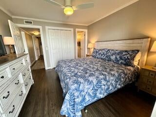 bedroom with ceiling fan, a closet, crown molding, and dark wood-type flooring