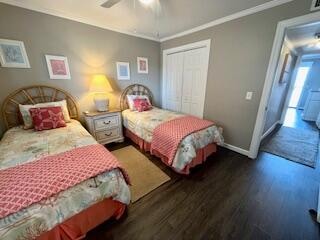 bedroom featuring a closet, dark hardwood / wood-style floors, crown molding, and ceiling fan