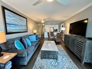 living room with crown molding, ceiling fan, and dark hardwood / wood-style flooring