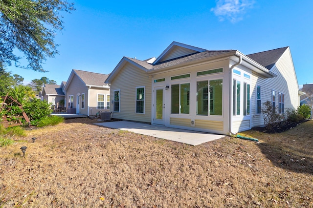 rear view of house featuring a yard and a patio