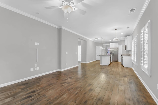 unfurnished living room featuring dark hardwood / wood-style flooring, ceiling fan, and ornamental molding