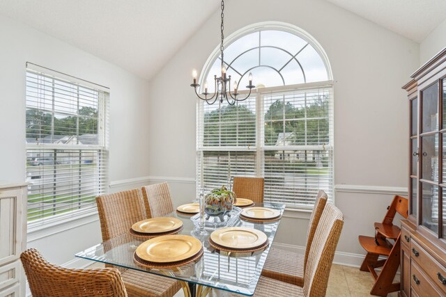 dining area featuring an inviting chandelier, vaulted ceiling, and light tile patterned flooring