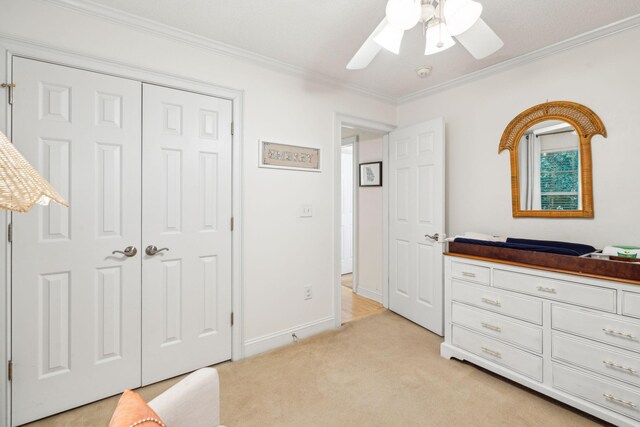 carpeted bedroom featuring ornamental molding, ceiling fan, and a closet