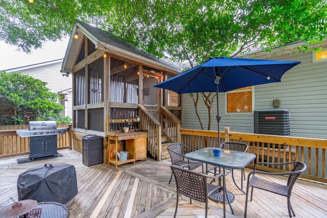 wooden terrace featuring grilling area, a sunroom, and central air condition unit