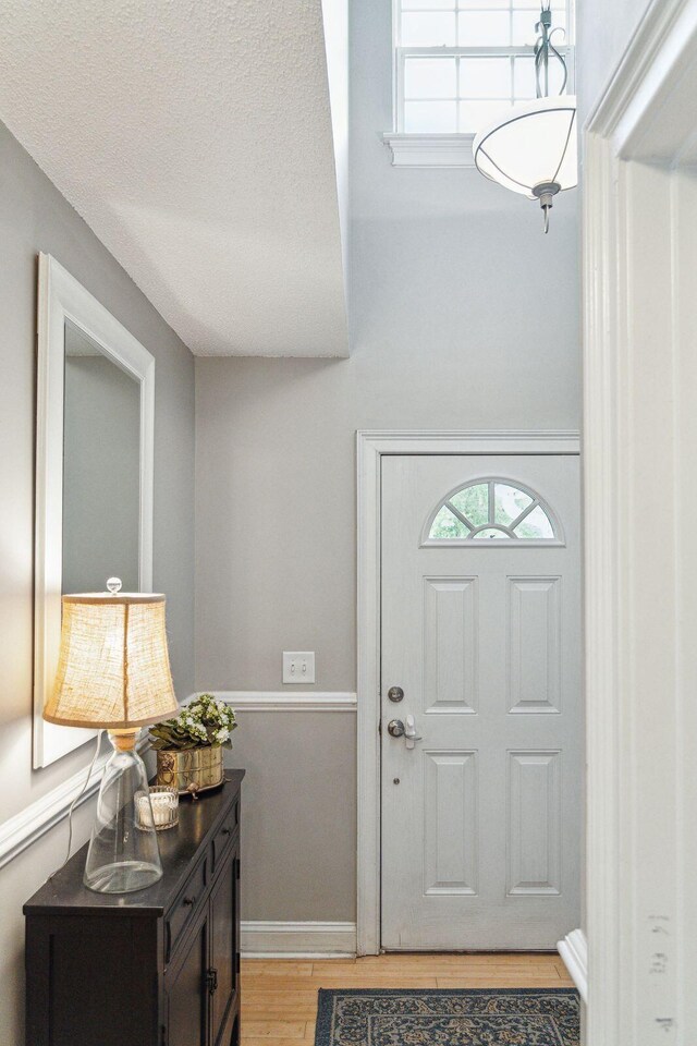 entrance foyer featuring a textured ceiling and light hardwood / wood-style flooring