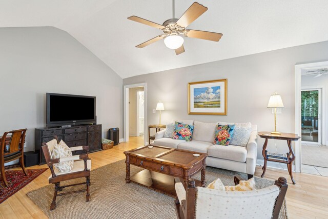 living room with light hardwood / wood-style flooring, vaulted ceiling, and ceiling fan