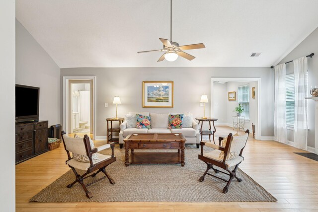 living room featuring light hardwood / wood-style flooring, lofted ceiling, and ceiling fan