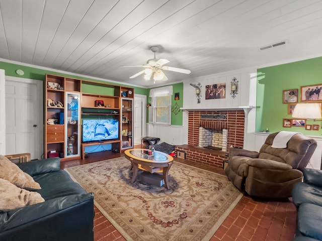 living room with ornamental molding, ceiling fan, and a fireplace