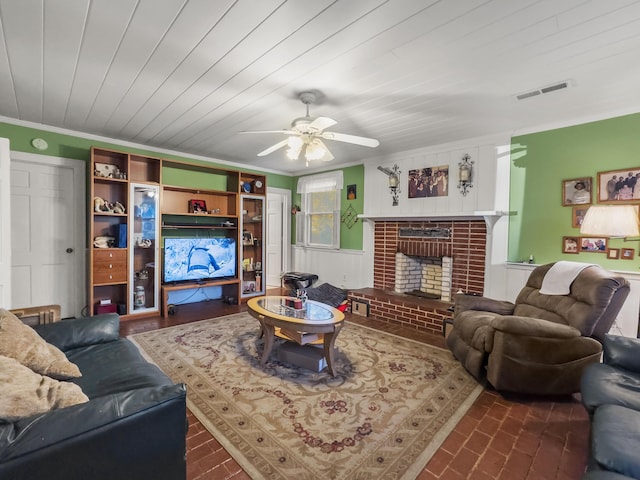 1104 2nd Ave, Kingstree, SC 29556 - living room featuring ceiling fan, crown molding, a brick fireplace, brick patterned flooring, and a wainscoted wall