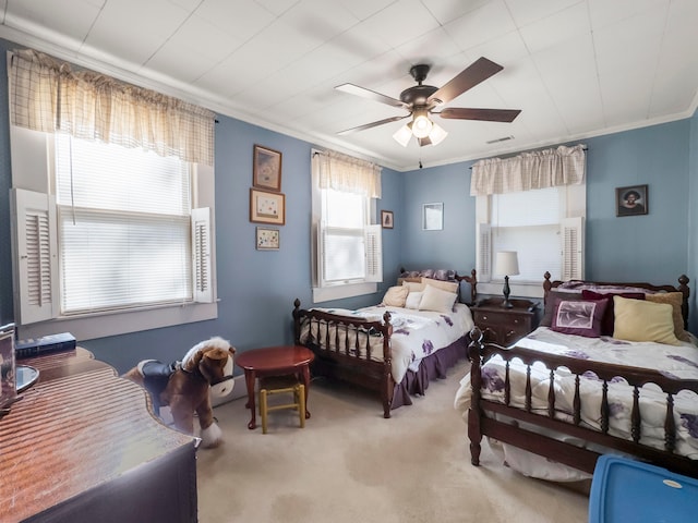 bedroom with carpet flooring, ceiling fan, and crown molding