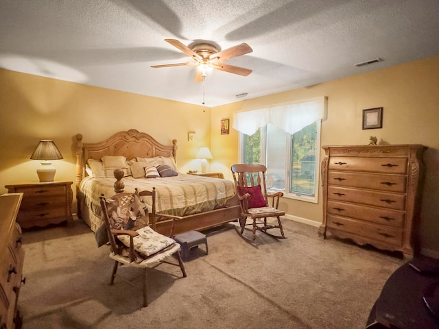 bedroom with ceiling fan, a textured ceiling, and light colored carpet