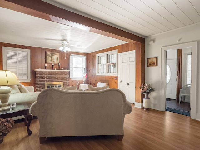 1104 2nd Ave, Kingstree, SC 29556 - living room with wooden walls, a ceiling fan, a brick fireplace, and dark wood-style floors