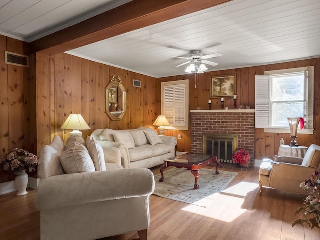 1104 2nd Ave, Kingstree, SC 29556 - living area featuring wooden walls, wood finished floors, a brick fireplace, a ceiling fan, and ornamental molding