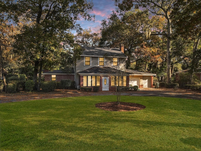 back house at dusk with a lawn