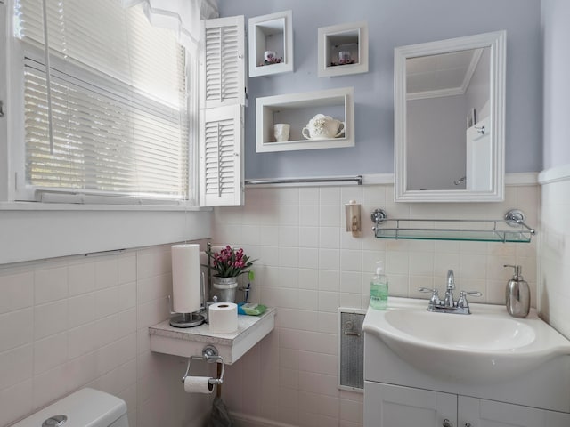 bathroom featuring tile walls, vanity, ornamental molding, and toilet