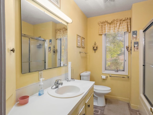 bathroom with a shower with door, vanity, a textured ceiling, tile patterned flooring, and toilet