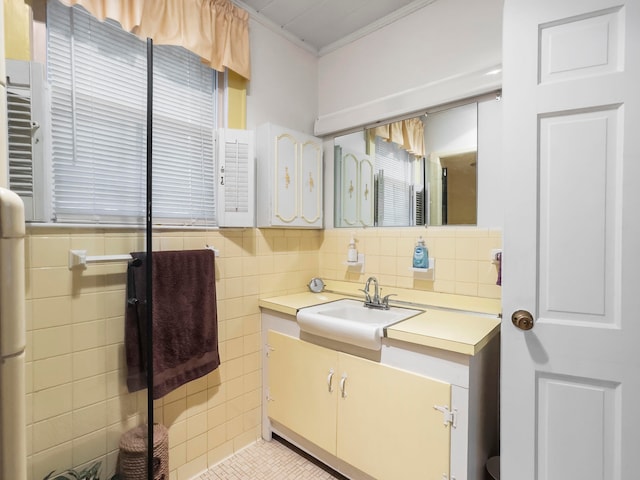 bathroom with tile walls, tile patterned flooring, vanity, and crown molding