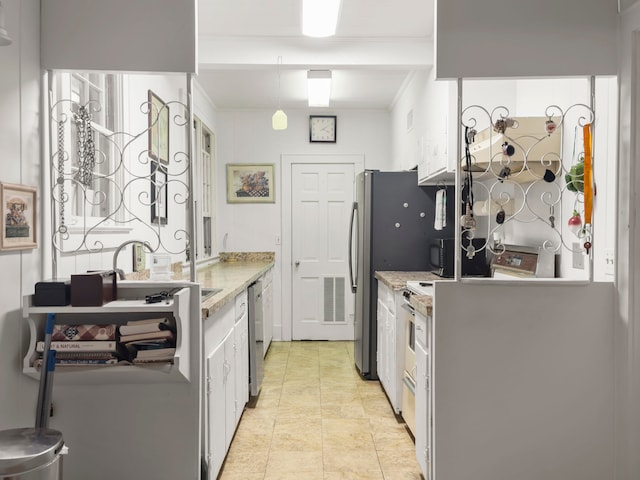 kitchen with light stone counters, ornamental molding, white cabinetry, appliances with stainless steel finishes, and sink