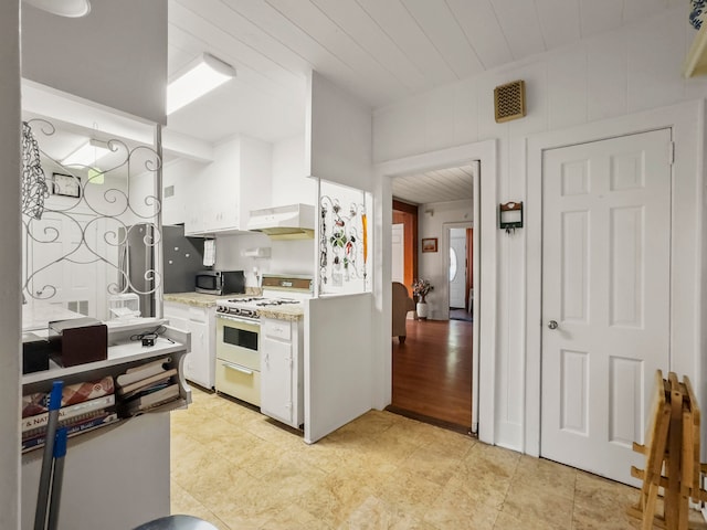 kitchen with white cabinets, light hardwood / wood-style floors, ventilation hood, and white gas range oven