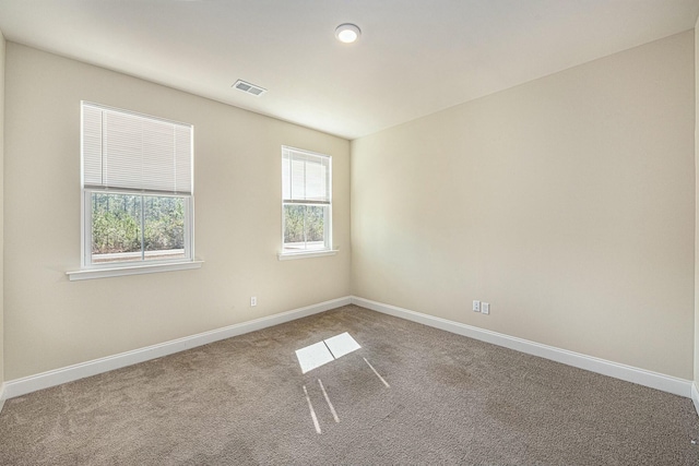 empty room featuring baseboards, visible vents, and carpet flooring