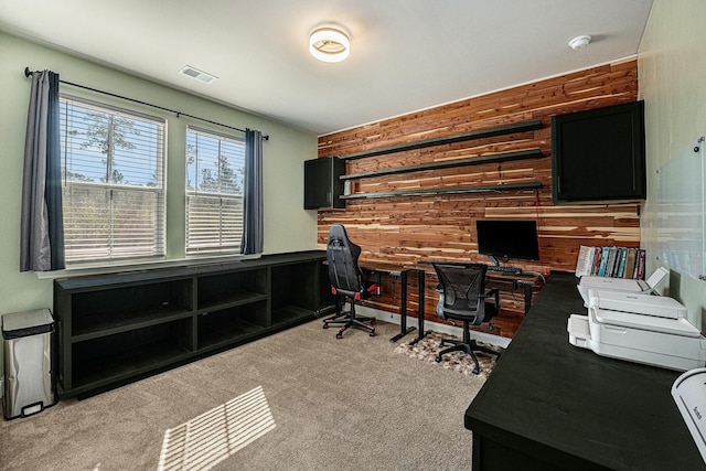 office area with carpet, visible vents, and wooden walls