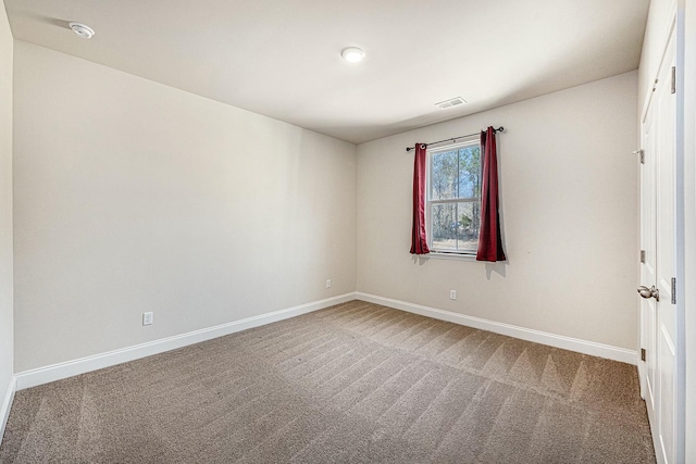 carpeted empty room featuring baseboards and visible vents